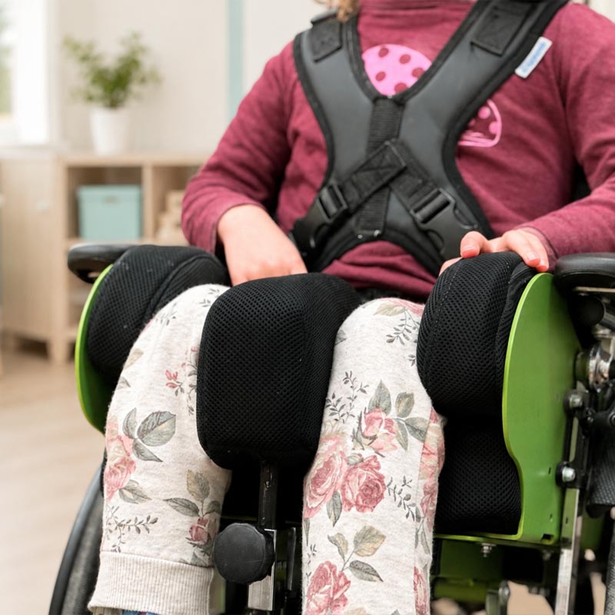Kind in individuell angepasster Sitzversorgung mit Rumpfgurt, Beinstützen und Positionierungshilfen im Bereich Kinder-Reha des KRIEGER Sanitätshauses