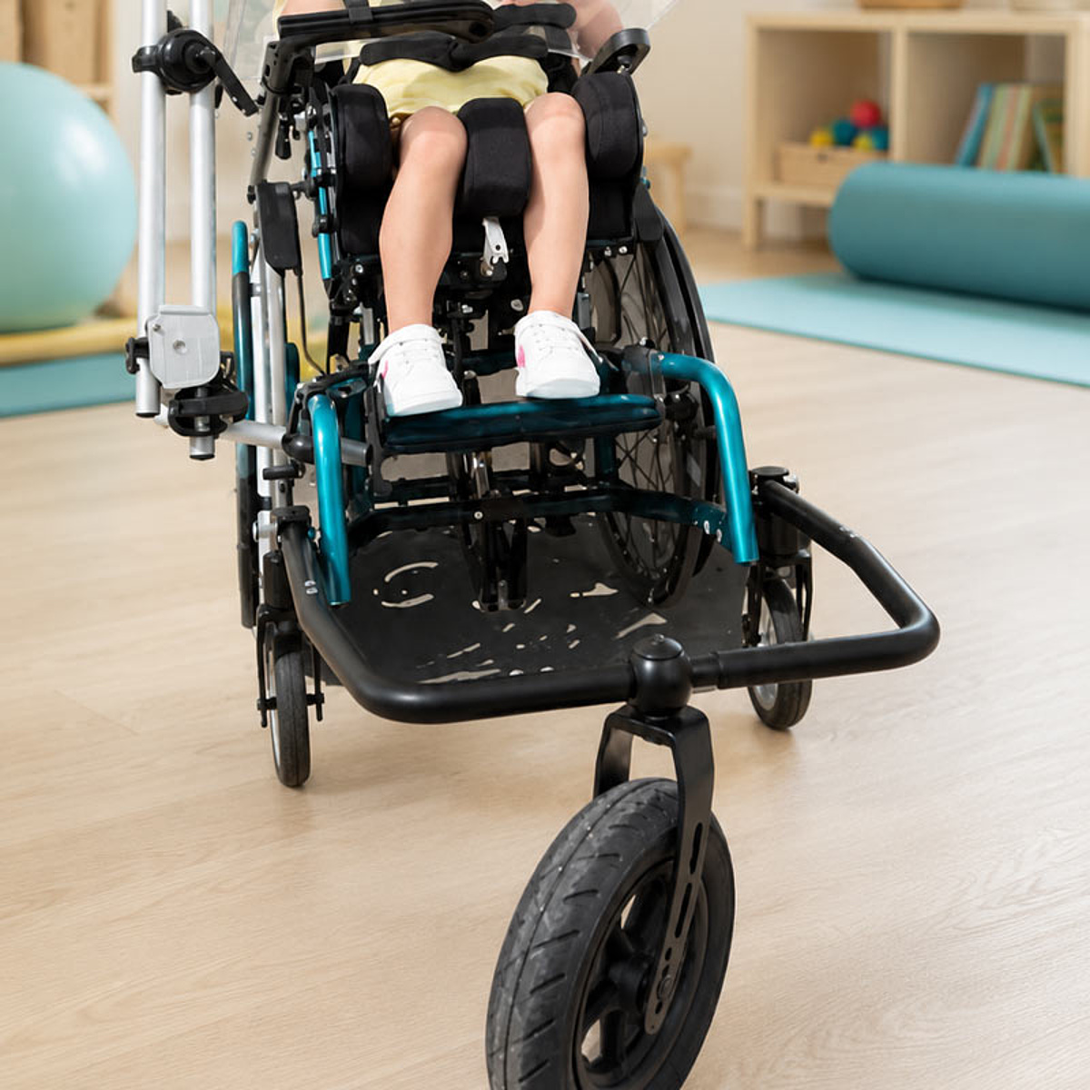 Kind in einem individuell angepassten Reha-Buggy mit großen Vorderrädern für sichere Mobilität im Alltag im Bereich Kinder-Reha des KRIEGER Sanitätshauses