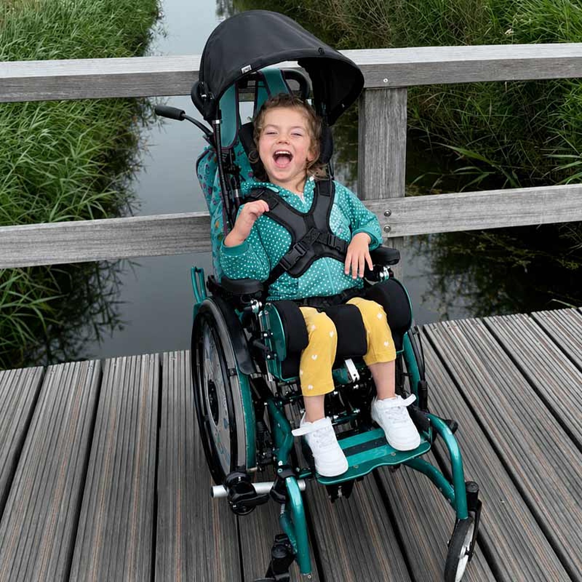 Kind in einem individuell angepassten Reha-Buggy für sichere und komfortable Mobilität unterwegs im Bereich Kinder-Reha des KRIEGER Sanitätshauses