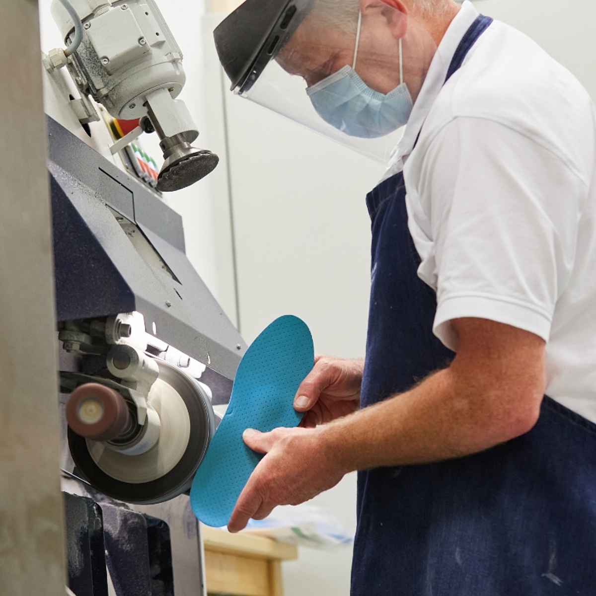 Unser Orthopädieschuhtechnik-Meister fräst an einer Schuheinlage.