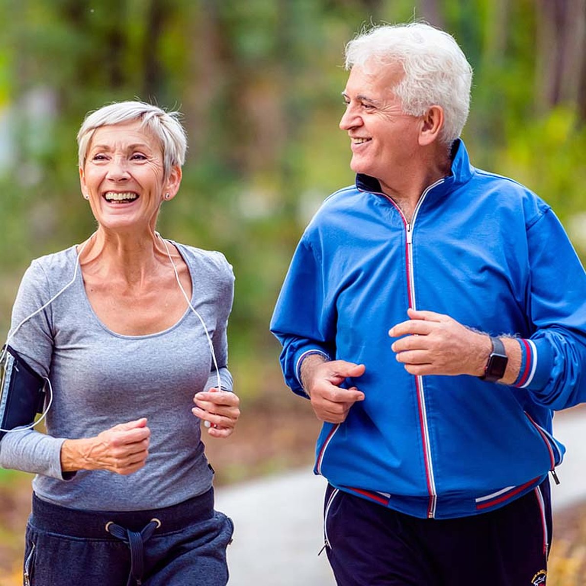 Ein Rentnerpaar joggt im Park.