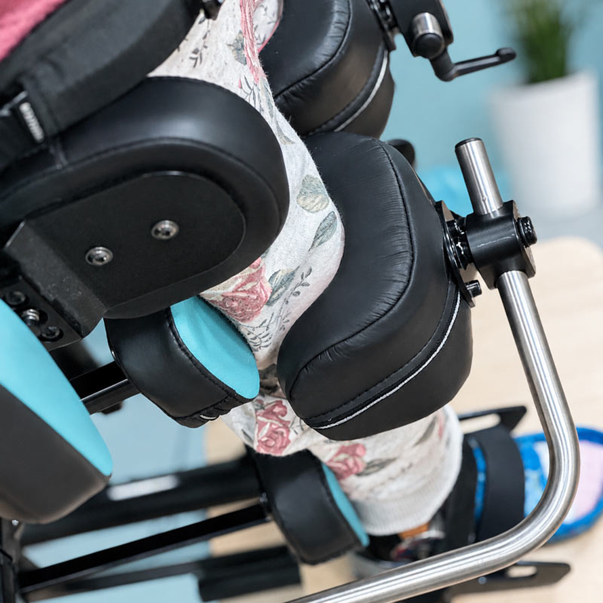 Beine eines Kindes in einem individuell angepassten Stehgerät mit gepolsterten Positionierungshilfen im Bereich Kinder-Reha des KRIEGER Sanitätshauses