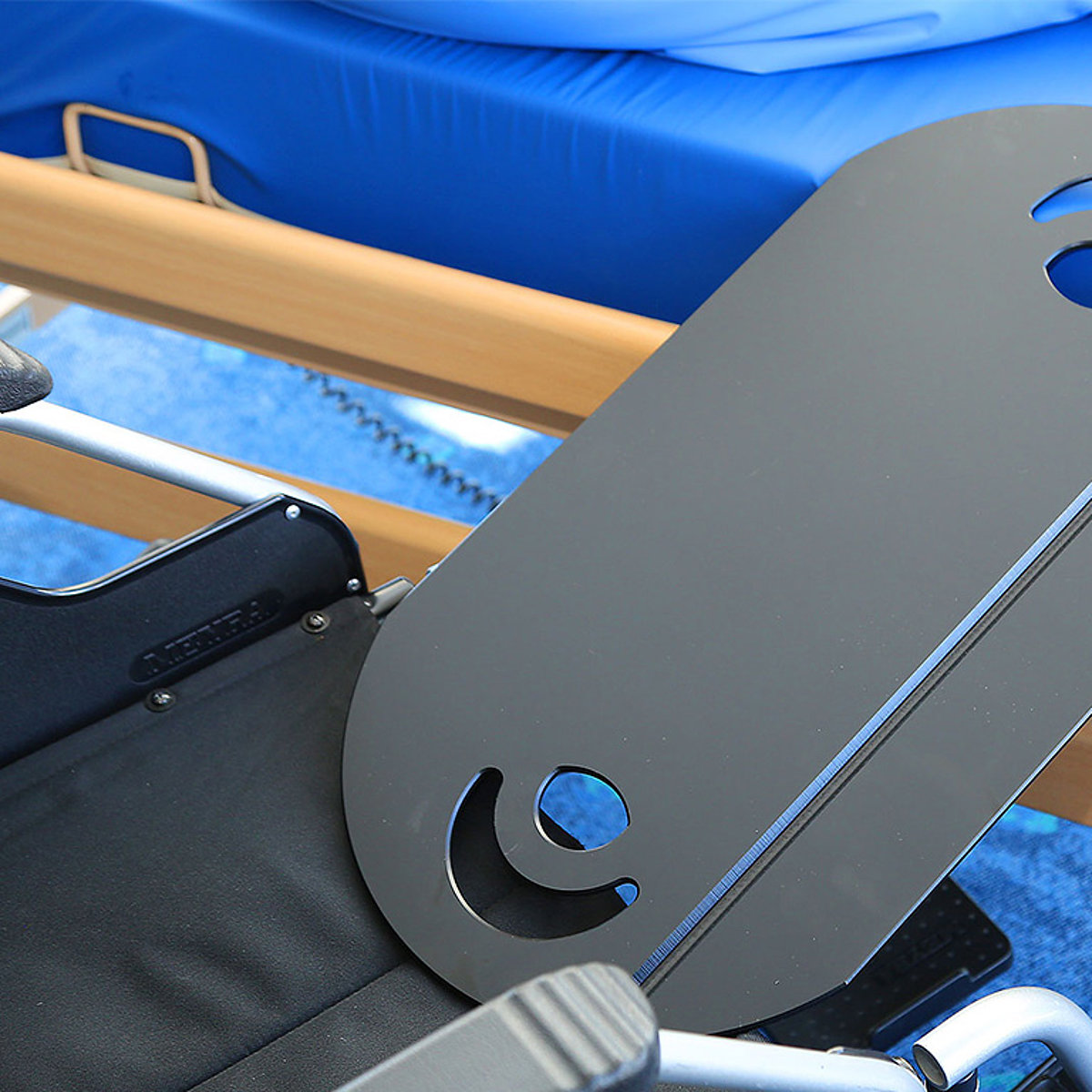 Eine spezielle Auflage ermöglicht einen fließenden Übergang von Pflegebett zu Rollstuhl.
