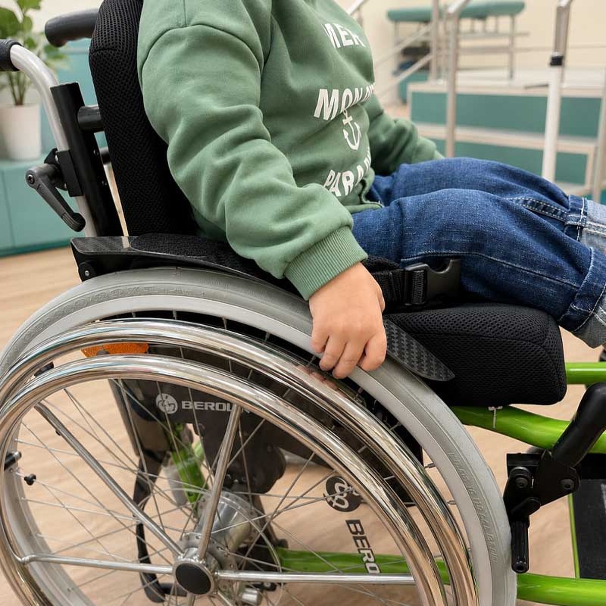 Kind in einem individuell angepassten Aktivrollstuhl mit Greifreifen im Bereich Kinder-Reha des KRIEGER Sanitätshauses