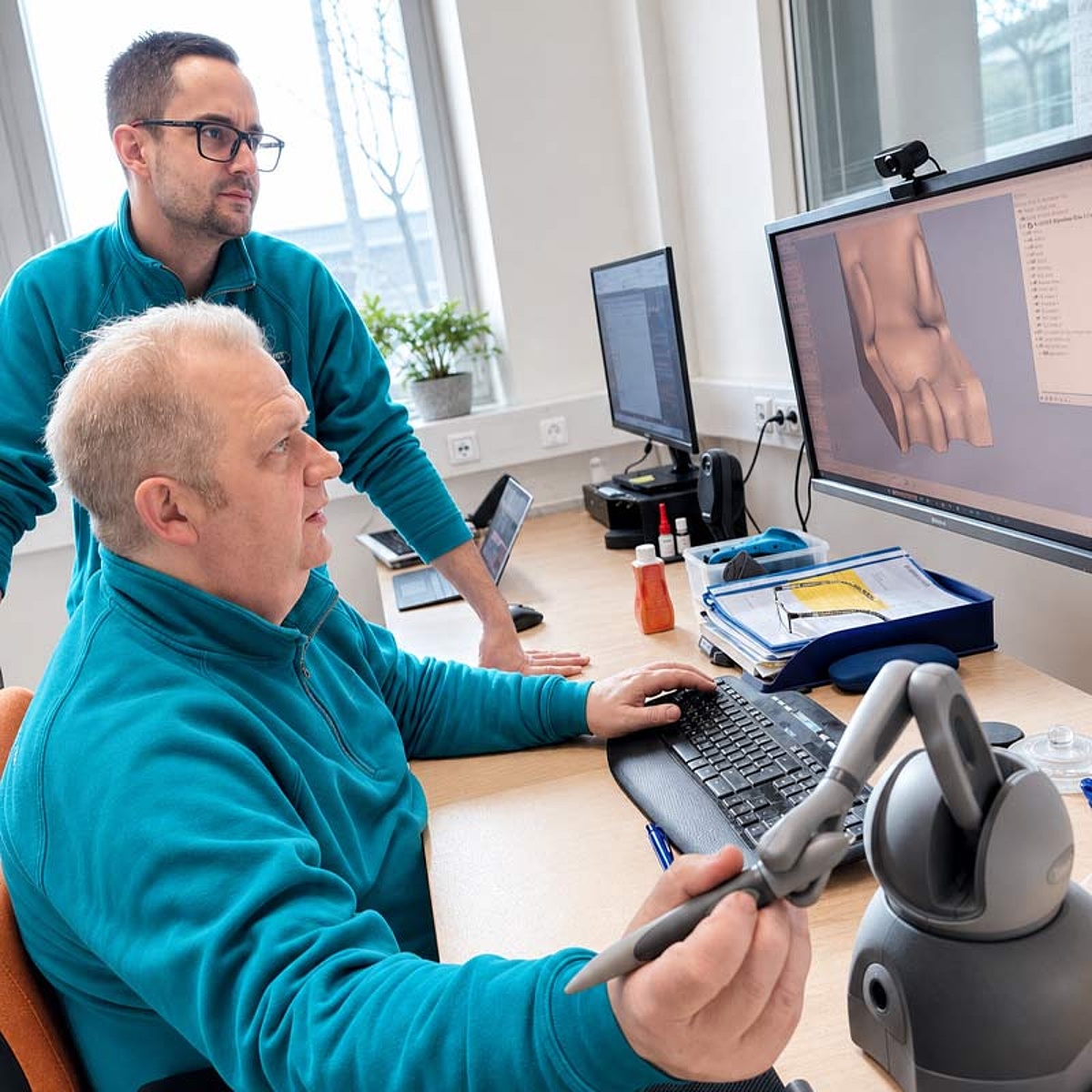 Mitarbeiter des KRIEGER Sanitätshauses bei der digitalen Modellierung einer individuellen Kinder-Reha-Sitzversorgung am Computer