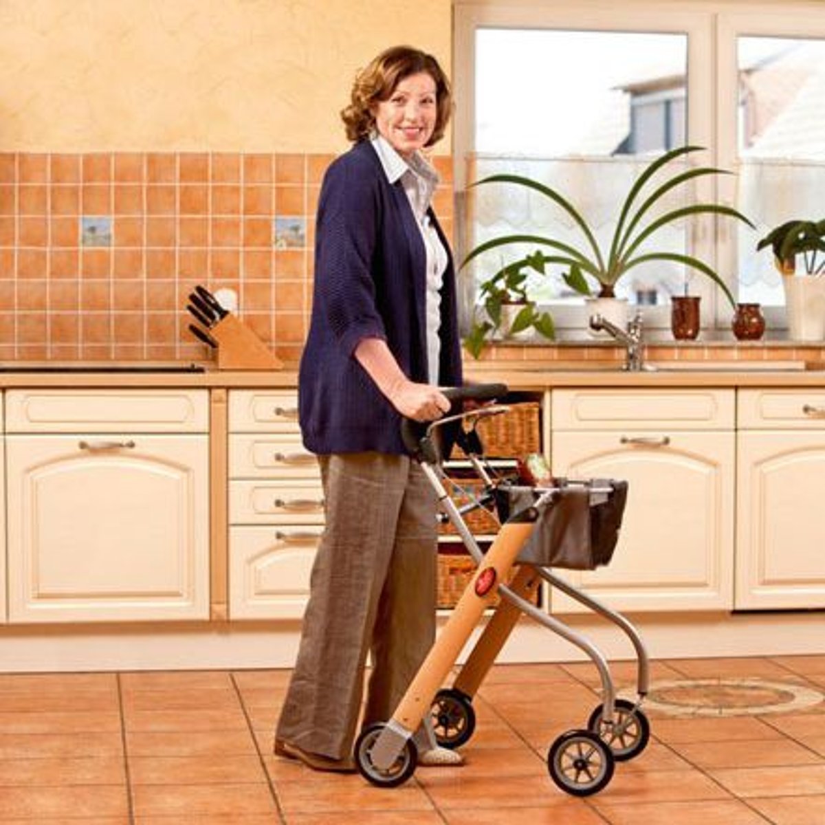 Eine Frau steht mit einem Inhaus-Rollator in der Küche.